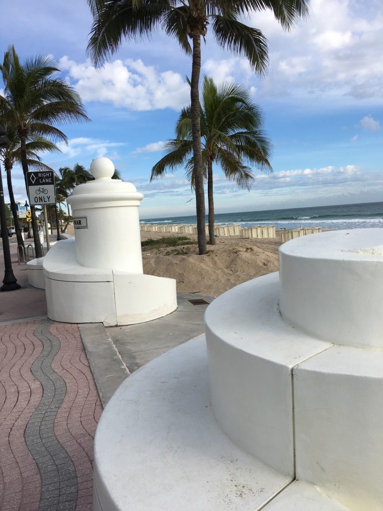 White Pillars on a Sidewalk Next to a Beach