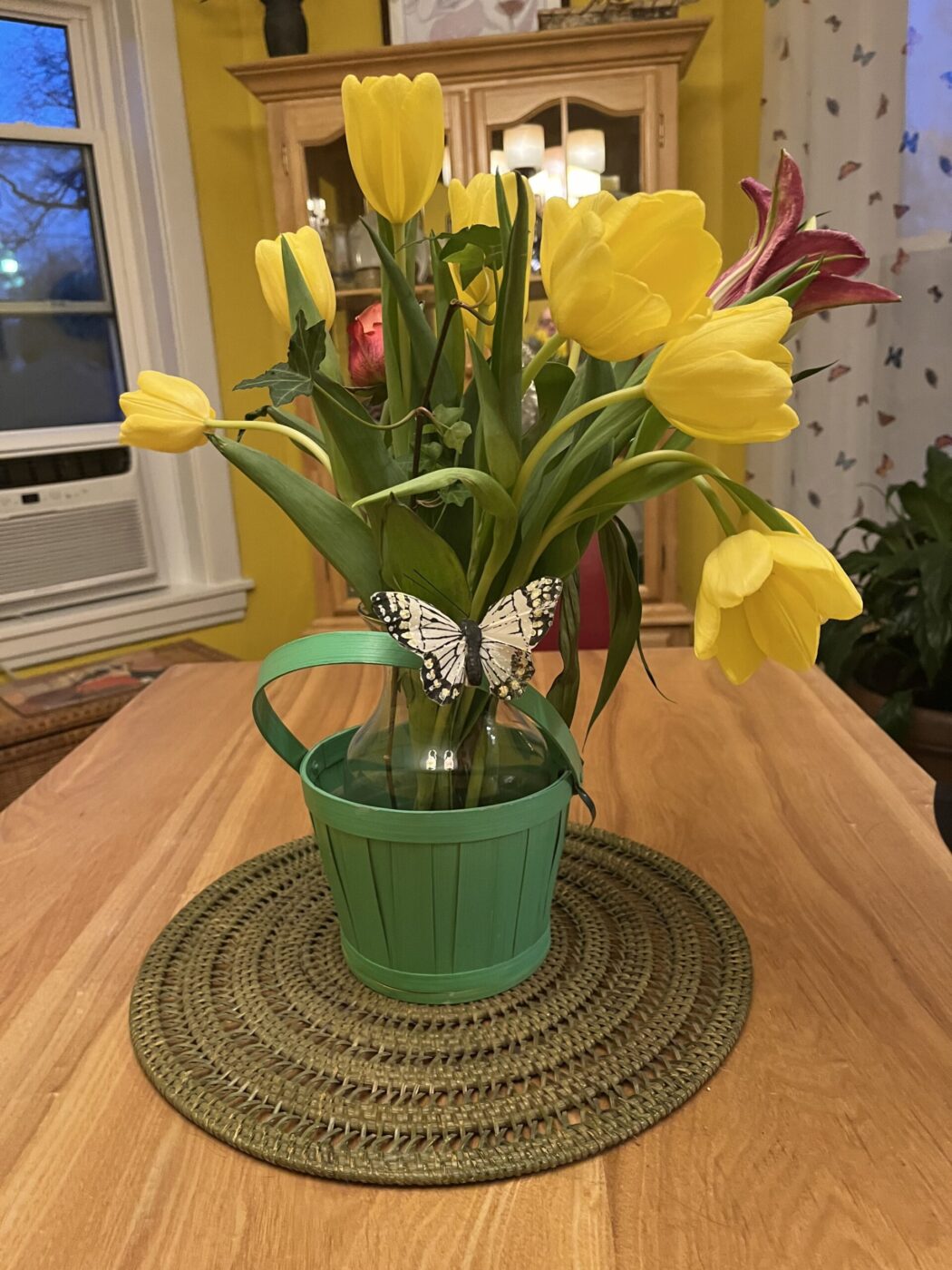 Yellow and Red Flowers in a Green Bucket and a Butterfly