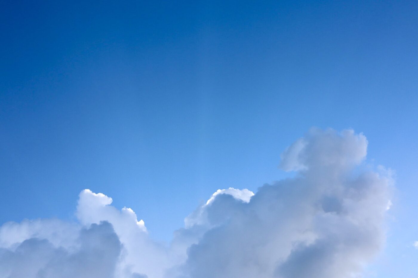 Fluffy white clouds against a bright blue sky, creating a serene atmosphere, ideal for discussions about weather or nature.